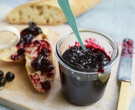 Blackcurrant jam in a jar and spread on toast
